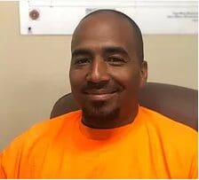Smiling person wearing bright orange shirt